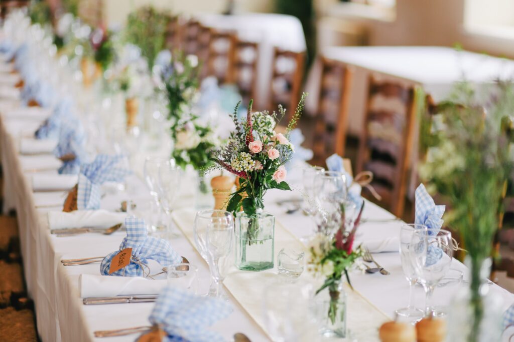 Long banquet table with place settings and flower vases